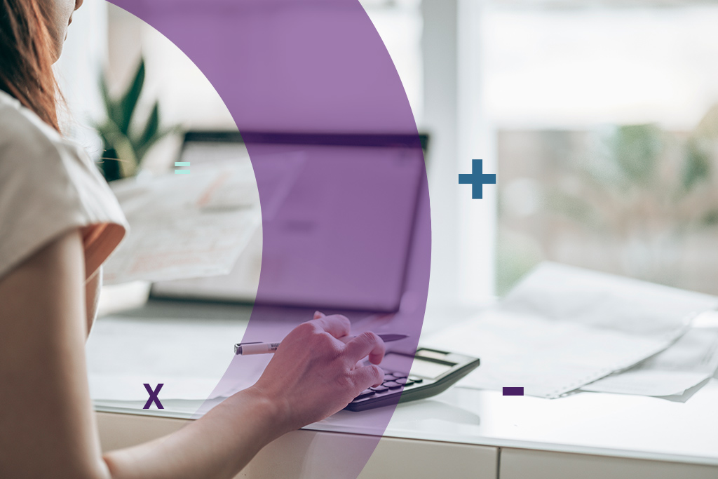 A woman using a calculator to track expenses