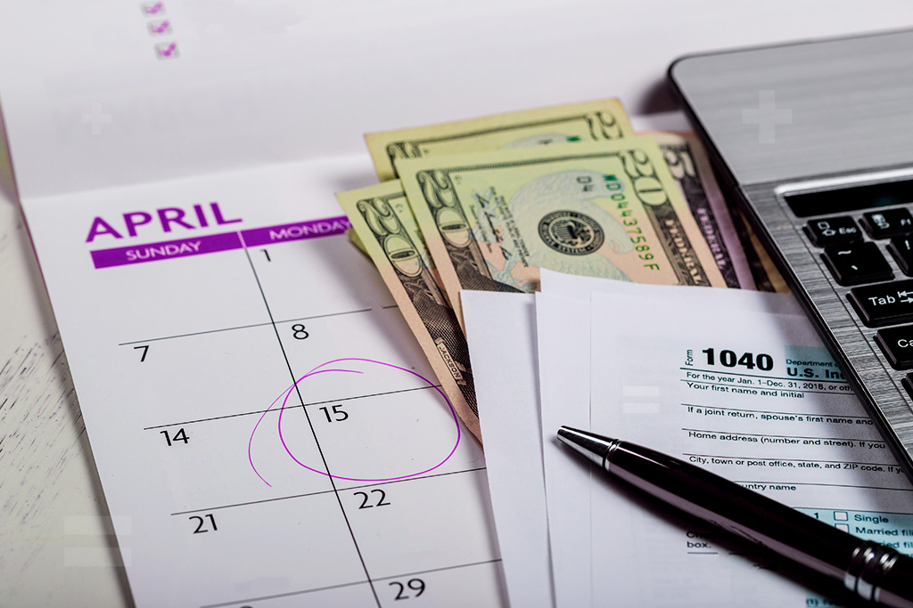 2025 calendar highlighting Tax Day on April 15, with tax forms and calculator in the foreground